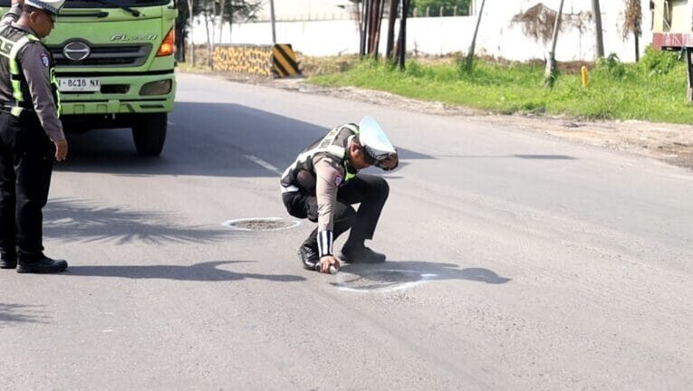 Jelang Nataru, Polres Gresik Tandai Jalan Berlubang di Raya Deandles Demi Keselamatan Pengendara
